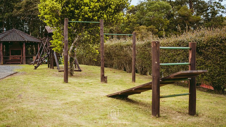 Chalé com sacada e lareira em meio à natureza